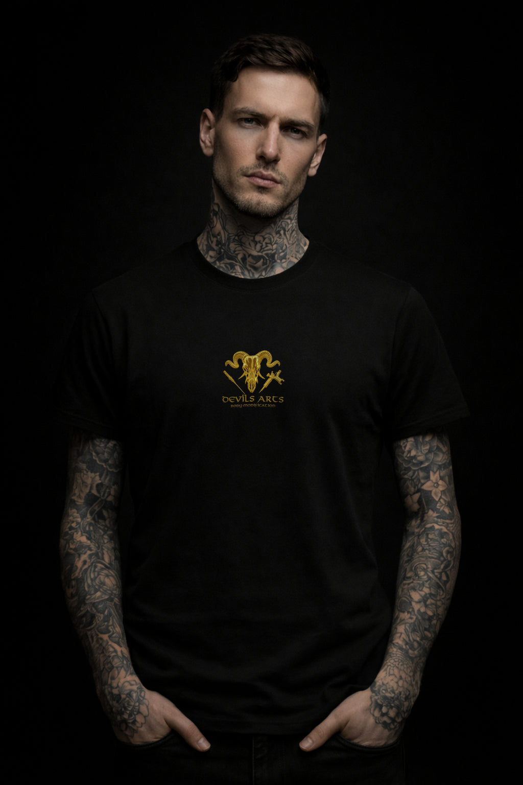 tattooed male model wearing black DEVILS ARTS gold skull logo t-shirt dark tattoo streetwear