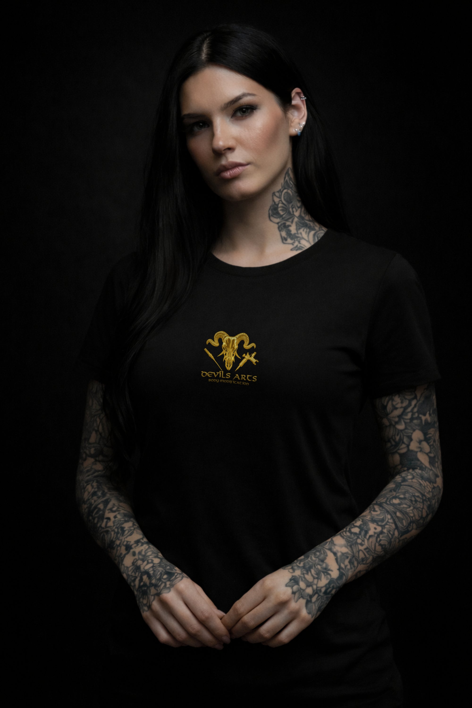 tattooed female model wearing black DEVILS ARTS gold skull logo t-shirt dark tattoo streetwear