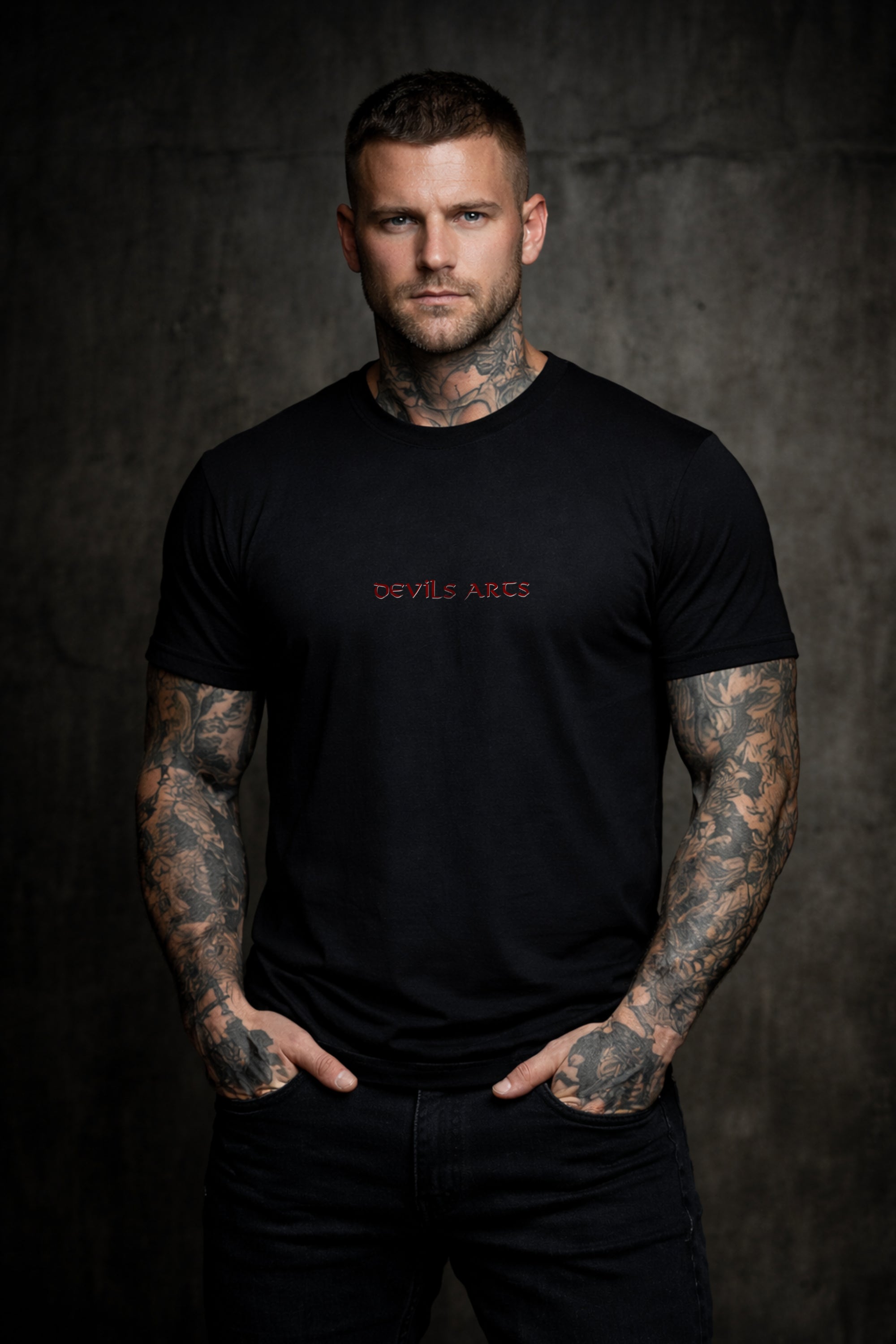 modello tatuato con T-shirt nera e tipografia DEVILS ARTS, dark tattoo streetwear
