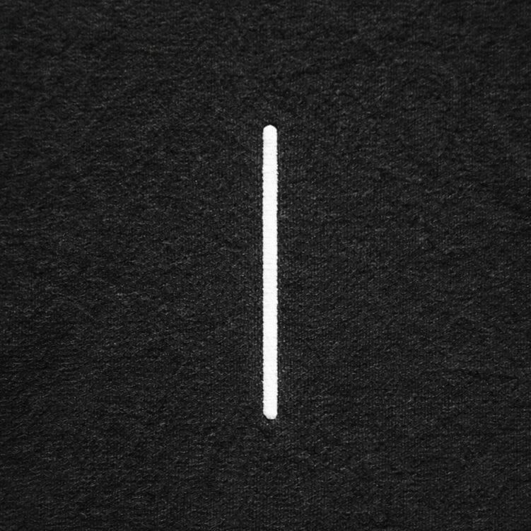 black t-shirt close-up of minimal vertical bar embroidered logo tattoo streetwear