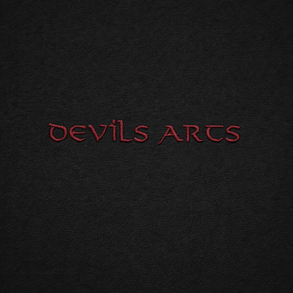 black t-shirt close-up of small bordeaux embroidered DEVILS ARTS logo tattoo streetwear